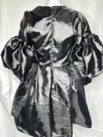 The Women Metallic Organza Black Pleated Dress features voluminous puffed long sleeves, a gathered flared skirt, and a back zipper, shown on a mannequin against a plain white background.