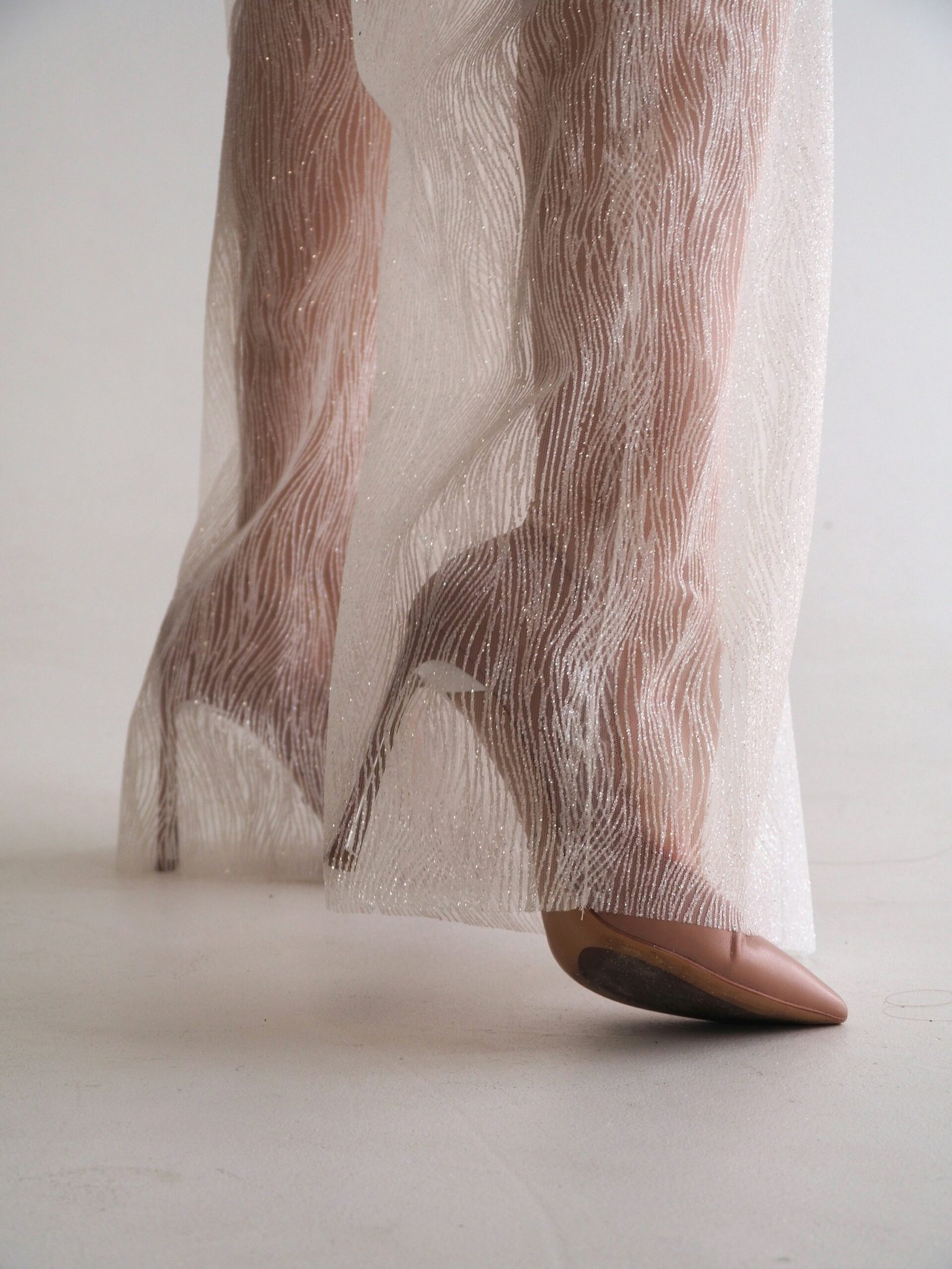 A woman's legs in high heels with sheer fabric