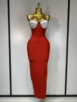 A gold mannequin showcases the Crystal Bust Long Bodycon Dress, a form-fitting, strapless red midi with a white, crystal-embellished bustier top. The dress creates an hourglass silhouette and is set against a plain white background.