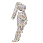 The Hollowed-Out Hip Irregular Ruffled Floral Dress features an asymmetrical design with one long sleeve, a diagonal waist cutout, and a ruffled cascading skirt in a yellow, purple, and green floral print on a light background.