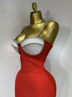 A gold mannequin models the Crystal Bust Long Bodycon Dress—form-fitting and red, with a white, jeweled bustier top and rhinestone straps—against a plain white background.