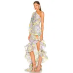 A woman wearing the Hollowed-Out Hip Irregular Ruffled Floral Dress with a pastel floral pattern and high-low hemline, styled with strappy high-heeled sandals.