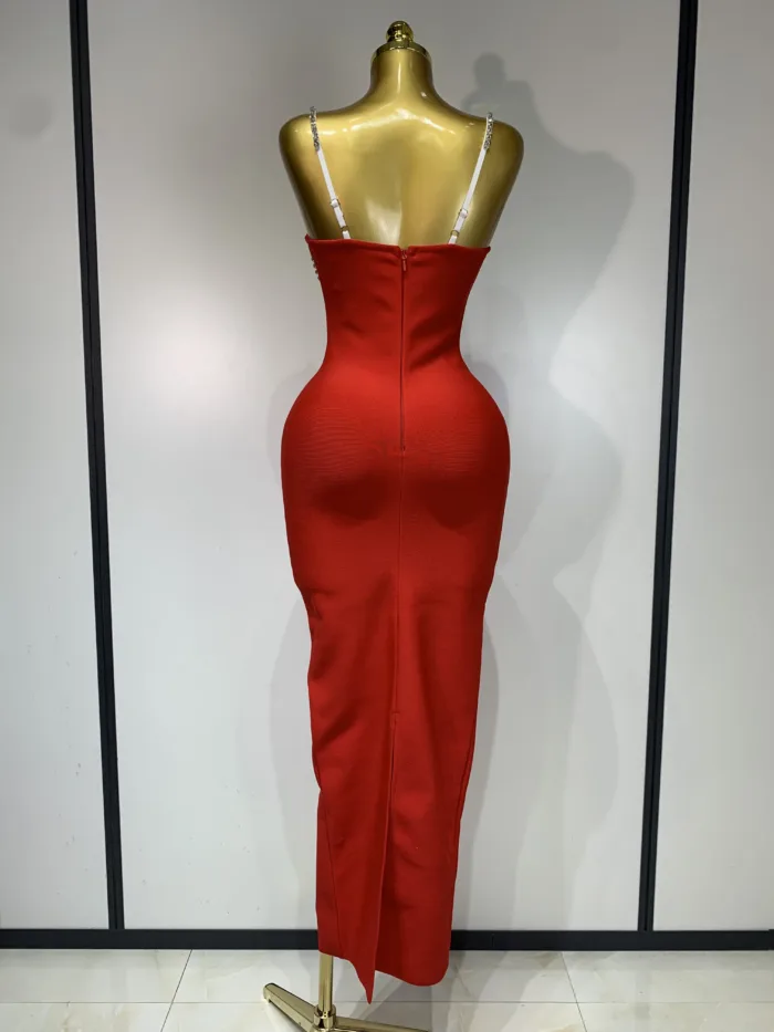 A gold mannequin displays the Crystal Bust Long Bodycon Dress—a form-fitting, sleeveless red dress with thin white straps, back zipper, ankle-length hem, and a back slit. The plain background features vertical panel lines.