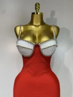 A gold mannequin showcases the Crystal Bust Long Bodycon Dress, featuring a white jeweled-trimmed bustier top, red body, and thin jeweled straps against a plain light background.