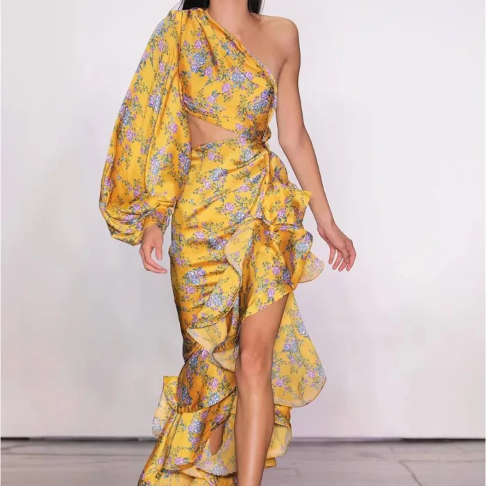 A model showcases the Hollowed-Out Hip Irregular Ruffled Floral Dress—a yellow, one-shoulder floral piece with waist cutout, ruffles, and an asymmetrical skirt—against a plain white background.