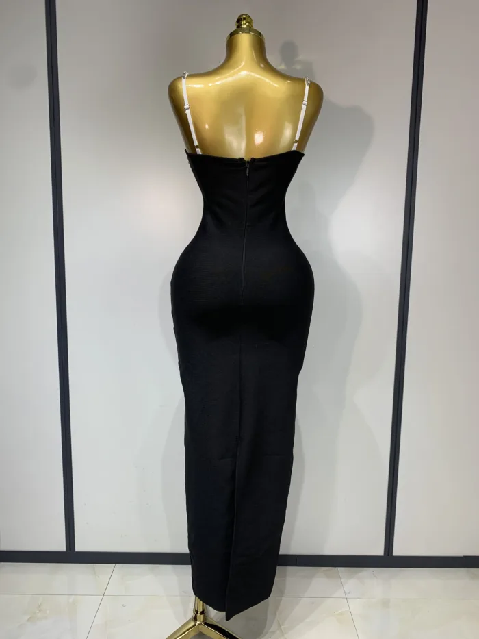 A gold mannequin showcases the Crystal Bust Long Bodycon Dress, a fitted strapless black maxi with a back zipper, set against a plain light wall with black trim.