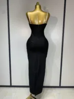 A gold mannequin showcases the Crystal Bust Long Bodycon Dress, a fitted strapless black maxi with a back zipper, set against a plain light wall with black trim.