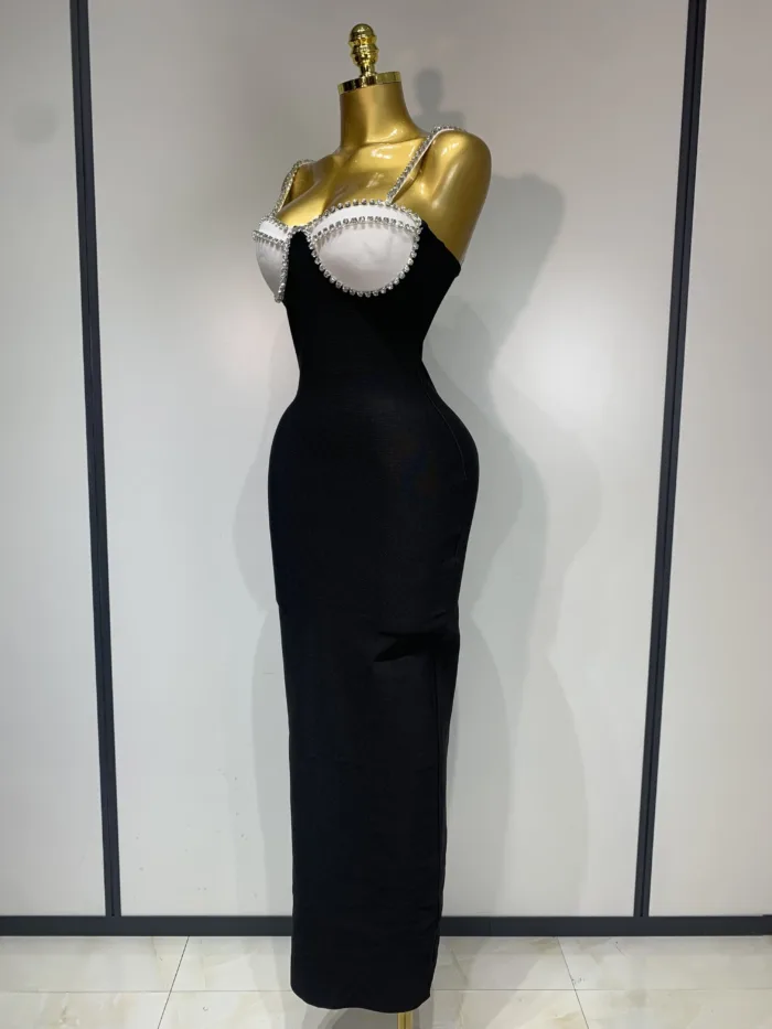 A gold mannequin showcases the Crystal Bust Long Bodycon Dress—a form-fitting, sleeveless black dress featuring a crystal-embellished bustier—set against a plain, light background.