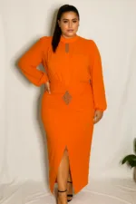 A plus-size model poses confidently in a vibrant orange chiffon and crepe dress with crystal embellishments, standing against a white backdrop.