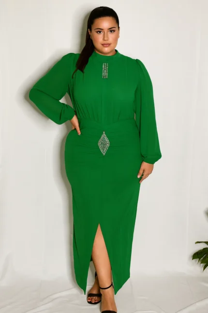 A plus-size model poses confidently in a vibrant green dress with crystal embellishments, standing against a white backdrop.
