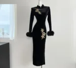 An image of a long sleeved embroidered dress featuring intricate floral patterns, fitted waist maxi dress,