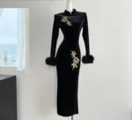 An image of a long sleeved embroidered dress featuring intricate floral patterns, fitted waist maxi dress,