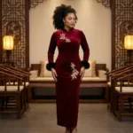 A woman wearing long sleeved embroidered dress featuring intricate floral patterns, fitted waist maxi dress,