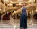 Woman in evening gown in elegant hotel lobby
