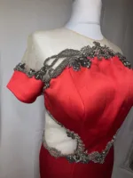 Close-up detail of the mesh and satin fabric on the red dress.